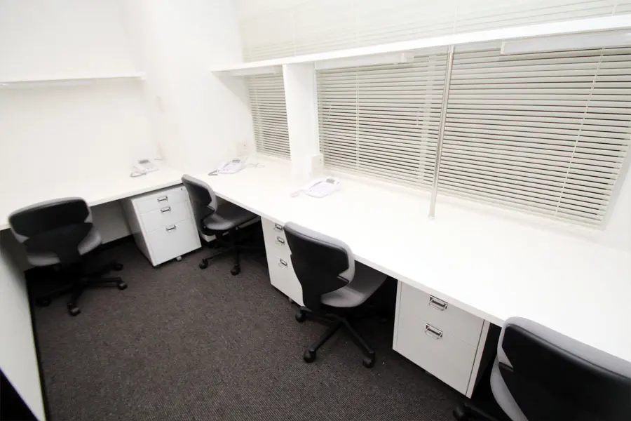 ブース_シックな配色のシンプルなオフィスです。壁の上部が30㎝ほど空いています。