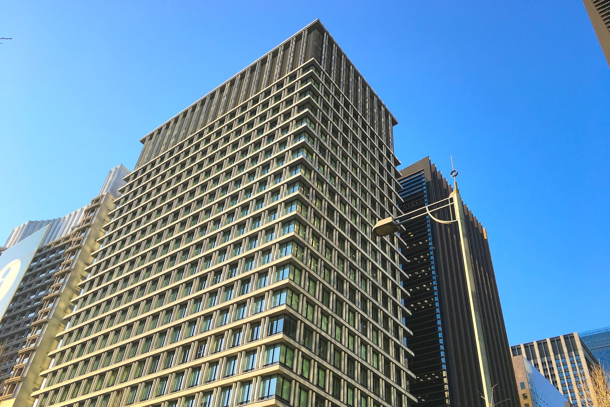Exterior view from the ground. The building is a highly visible office building facing Hibiya Street.