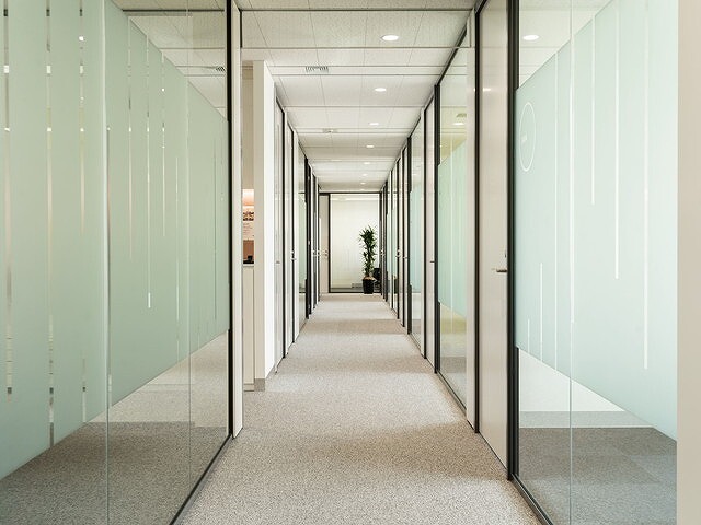 廊下。壁がスモーク入りのガラス張りになっており、オープンな印象を与えます。